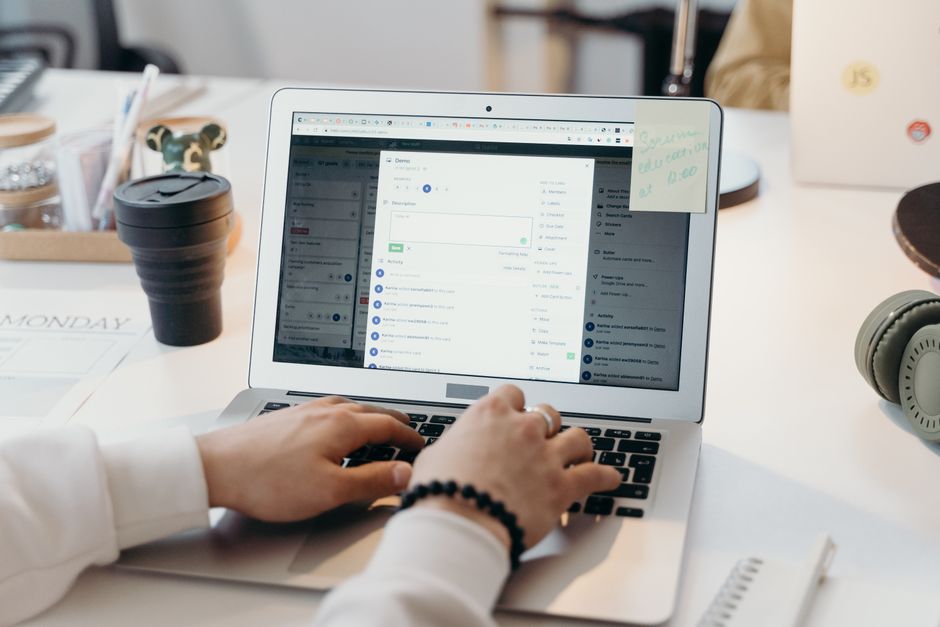 A person looking at a laptop with a full email inbox, surrounded by office items.