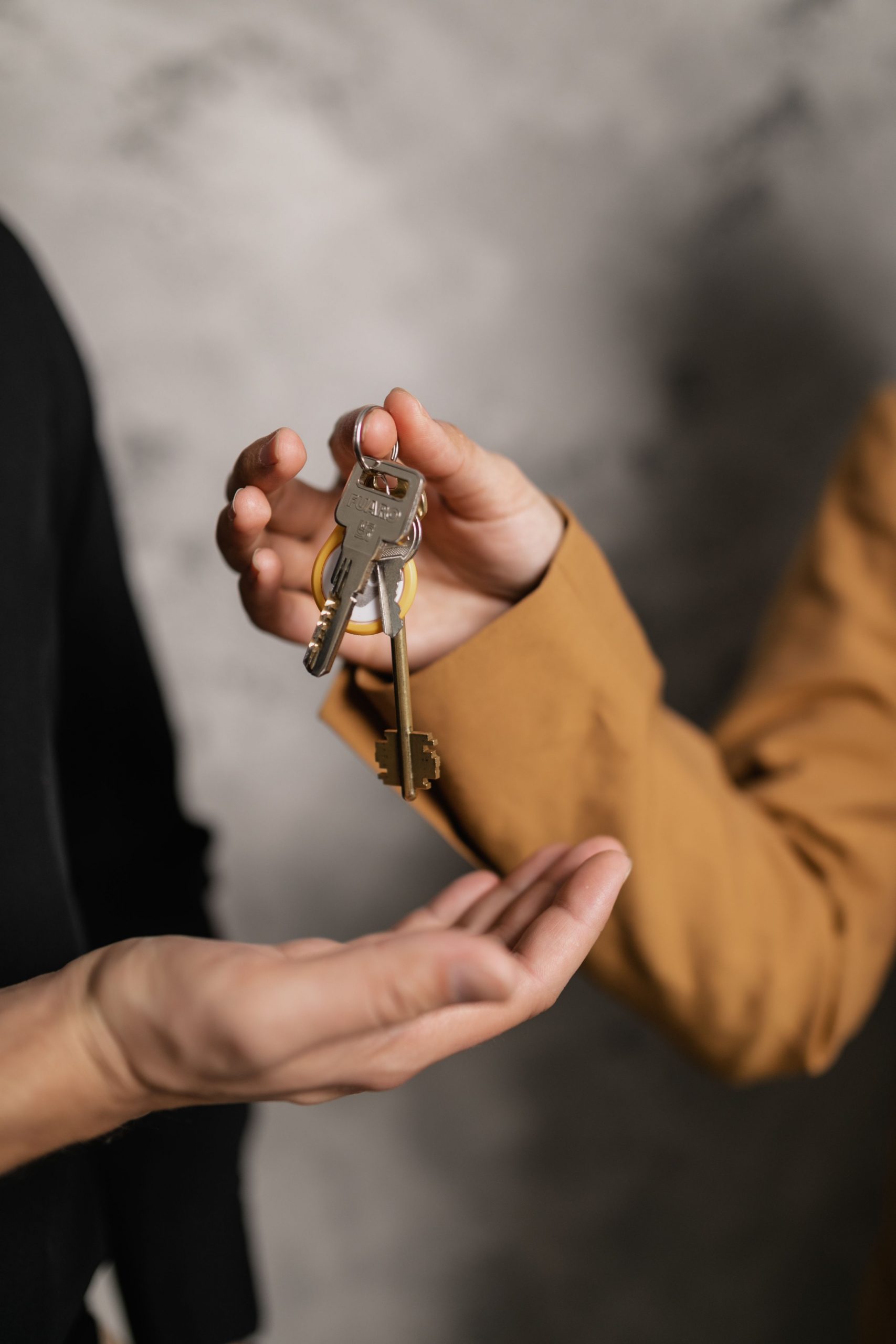 A person handing another person a key ring.